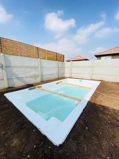 Piscina de fibra instalada en el patio, con agua, lista para disfrutar