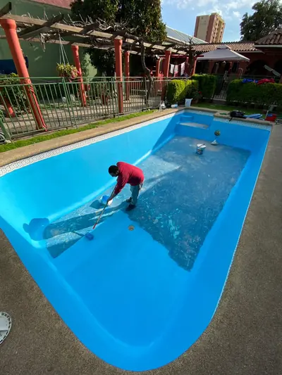 Piscina de hormigón recién pintada de azul, vista desde el borde