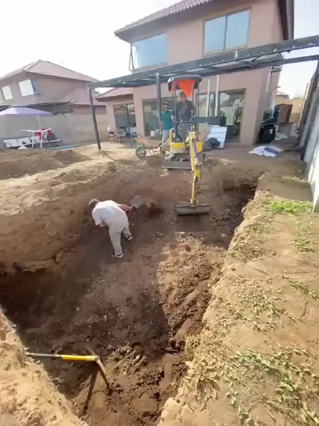 Excavación del terreno con miniexcavadora para instalar la piscina
